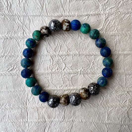 A beaded stretch bracelet made of polished round gemstone beads in blue, green, gunmetal, and brown.